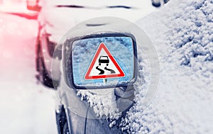 Winter driving - warning sign - risk of snow and ice. Winter driving - caution. Black Ice. Concept of snow in the road. Car hit a