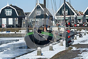 Winter in Durgerdam with frozen pond and colourful wooden houses