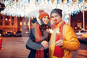 Winter evening, love couple with sparklers outdoor