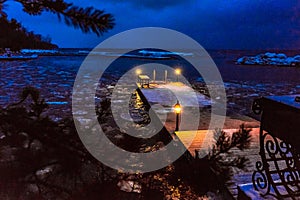 Winter evening seascape with a pier, warm lights, right