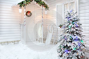 Winter exterior of a country house with Christmas decorations in the American style.