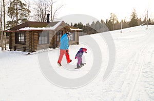 Winter extreme sport. Father is teaching his little daughter snowboarding on a snow slope at ski resort