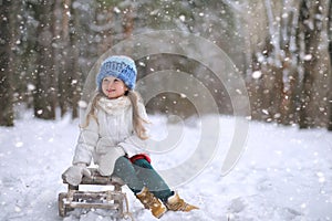A winter fairy tale, a young girl rides a sled