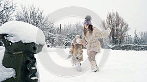 winter family activity outdoors. side view. Happy little girls, children are slowly walking through thick snow in the