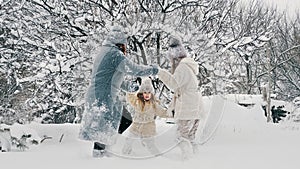 winter family fun. Happy family is enjoying of snow and snowfall, having fun outdoors, spending time together on snowy