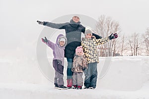 Winter family portrait. Mom with three daughters are walking in the park. Family laughing outdoors. Enjoying nature, wintertime