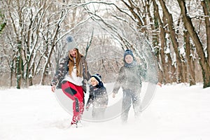 Winter family vacation. Lovely family throwing snow and having fun together. Outdoor winter activities