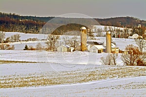 Winter farm scene of roling hills and farm building