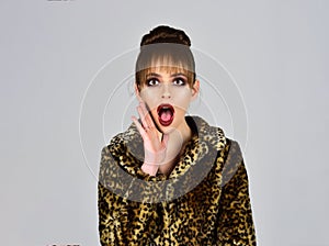 Winter fashion and beauty. Woman in leopard fur coat on grey background. Fur coat boutique with natural and artificial