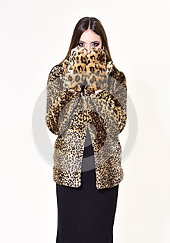 Winter fashion and beauty. Woman in leopard fur coat isolated on white. Look of fashion model with bad taste. Leopard