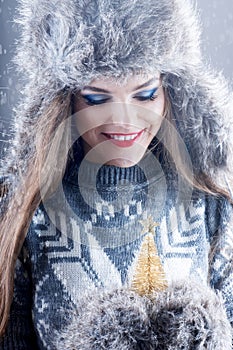 Winter fashion portrait of young smiling girl in fur hat.