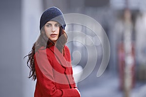 Winter, fashion and woman with jacket in city for travel and walking commute in cool style with red coat. Streetwear