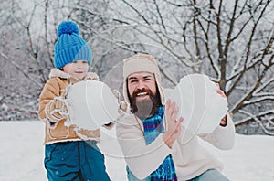 Winter, father and son play outdoor. Enjoying nature wintertime. Winter portrait of dad and child in snow Garden. Father