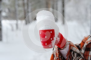 Winter female hand holding a red Cup.