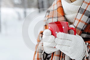 Winter female hand holding a red Cup.