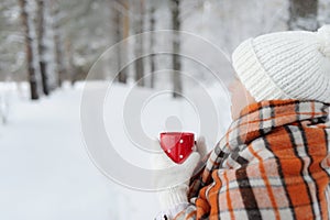 Winter female hand holding a red Cup.