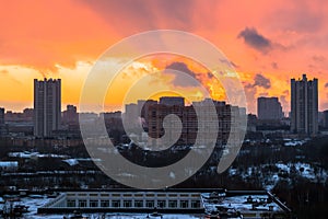 Winter fiery dawn over the city. Panoramic view of a modern residential area and a delightful sky in the background.