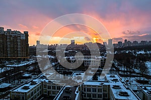 Winter fiery dawn over the city. Panoramic view of a modern residential area and a delightful sky in the background.