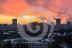 Winter fiery dawn over the city. Panoramic view of a modern residential area and a delightful sky in the background.