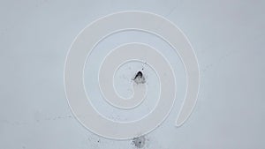 Winter fisherman fishing on frozen lake aerial view. Winter fishing on ice lake drone view.