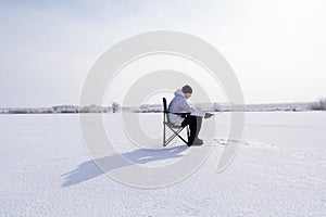Winter fisherman on frozen lake