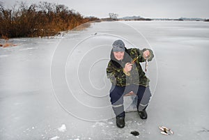 Winter fisherman on the river catching fish