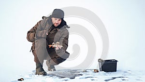 Winter fishing. Fisherman on the background of a frozen lake