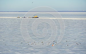 Winter fishing fishermans on the ice frozen water. Small Submarine in the ice