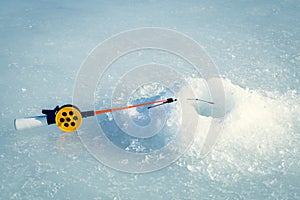 Winter fishing. Fishing rod with ice hole