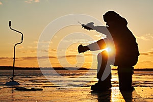 Winter fishing on ice. fisherman or angler hooking the fish