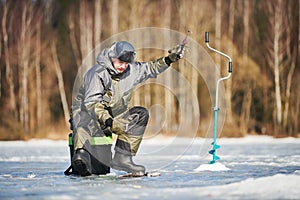 Winter fishing on ice. fisherman or angler hooking the fish