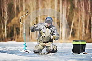 Winter fishing on ice. fisherman or angler hooking the fish