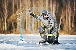 Winter fishing on ice. Fisherman hooking fish. Biting