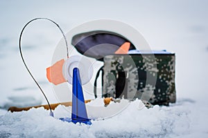 Winter fishing on the lake and fishermen on the ice in the background.