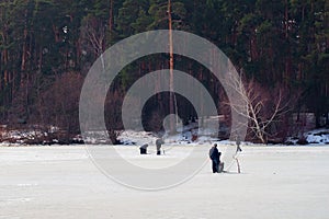 Winter fishing. River, lake near forest in ice. Anglers, Fishermens during your favorite leisure time.