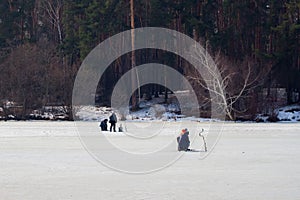 Winter fishing. River, lake near forest in ice. Anglers, Fishermens during your favorite leisure time. Copy space, for