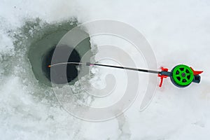 Winter fishing. Winter fishing rod next to the hole in the ice