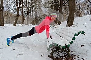 Winter fitness and running in park: happy woman runner warming up and exercising before jogging in snow