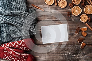 Winter flatlay with cozy home sweater, mittens, blank greeting card and spices for mulled wine