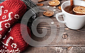 Winter flatlay with cozy home sweater, mittens, cup of black tea and spices for mulled wine