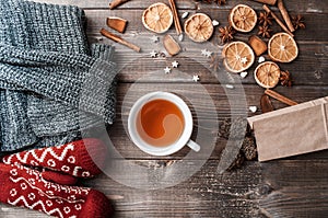 Winter flatlay with cozy home sweater, mittens, cup of tea and spices for mulled wine