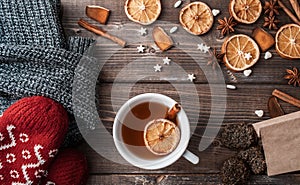 Winter flatlay with cozy home sweater, mittens, cup of tea and spices for mulled wine