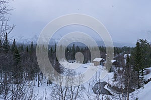 Winter forest in the mountains, snowstorm, snowfall, romance, river and house
