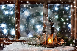 Winter  frost window with burning lantern, Christmas  or Advent time