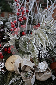 Winter frosted berries and greenery with large wooden button