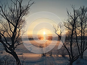 Winter frosty sunset over the frozen snow-covered river 1