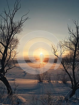 Winter frosty sunset over the frozen snow-covered river 1