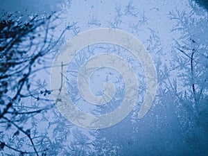winter through frozen glass abstract background. wintry frosty pattern on glass. abstract background of ice frozen window