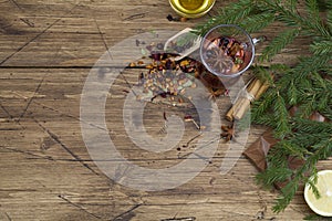 Winter fruit hot tea with honey, cinnamon , chocolate and christmas tree branch on wood background.