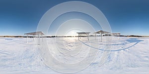 Winter full spherical seamless panorama 360 degrees angle view snow covered deserted beach with gazebos near lake  in snowy park